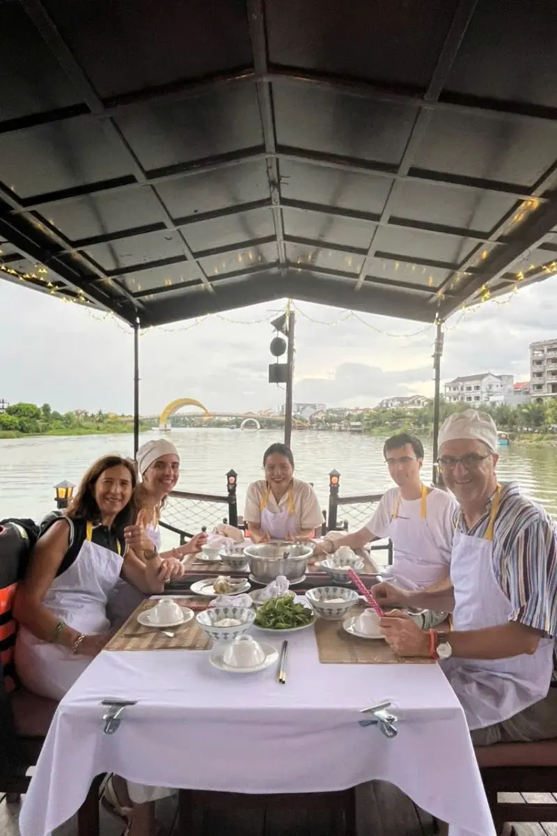 Travelers enjoying a riverside lunch cruise during a cultural day trip from da nang tours